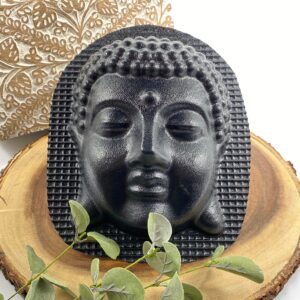 Finished dark concrete Buddha head wall relief styled with foliage