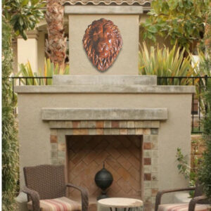 Large cast concrete lion head wall relief installed above an outdoor fireplace